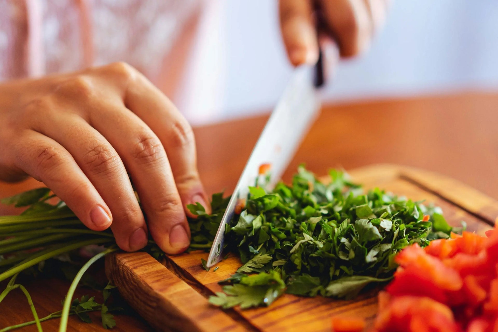 a home chef chopping parsely with a chef knife